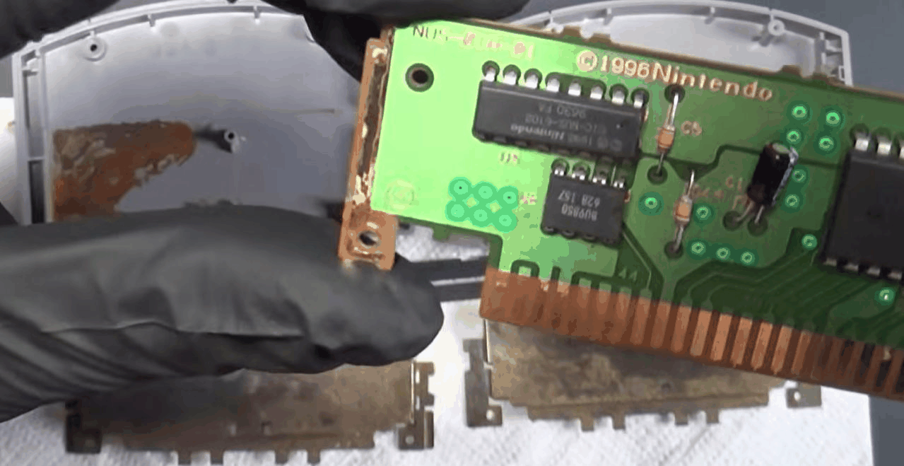 打开外壳后的 N64 卡带 PCB，金属屏蔽罩锈迹斑斑