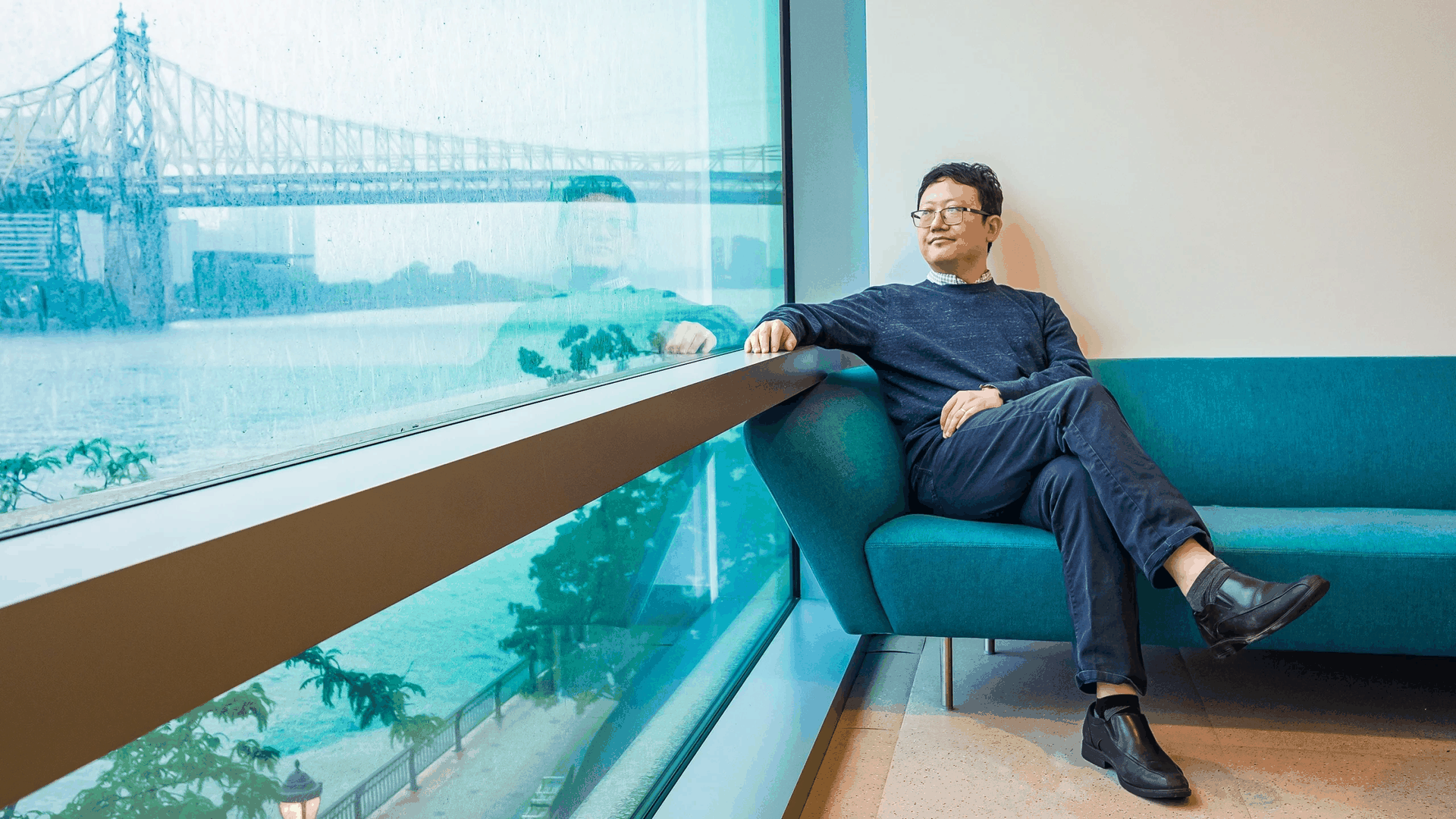 曹俊越坐在蓝色沙发上望向窗外