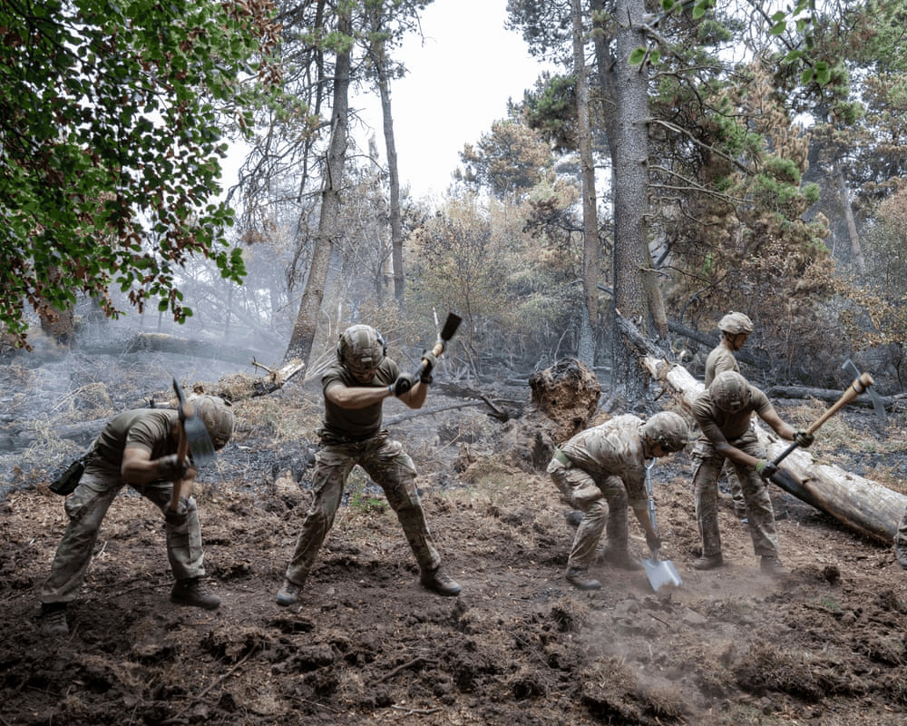 Military personnel cutting firebreaks to stop fire spread